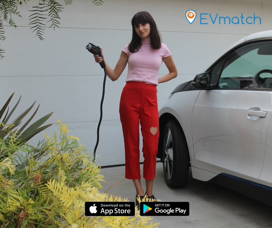 Woman holding EV charger while standing next to her vehicle outside her home